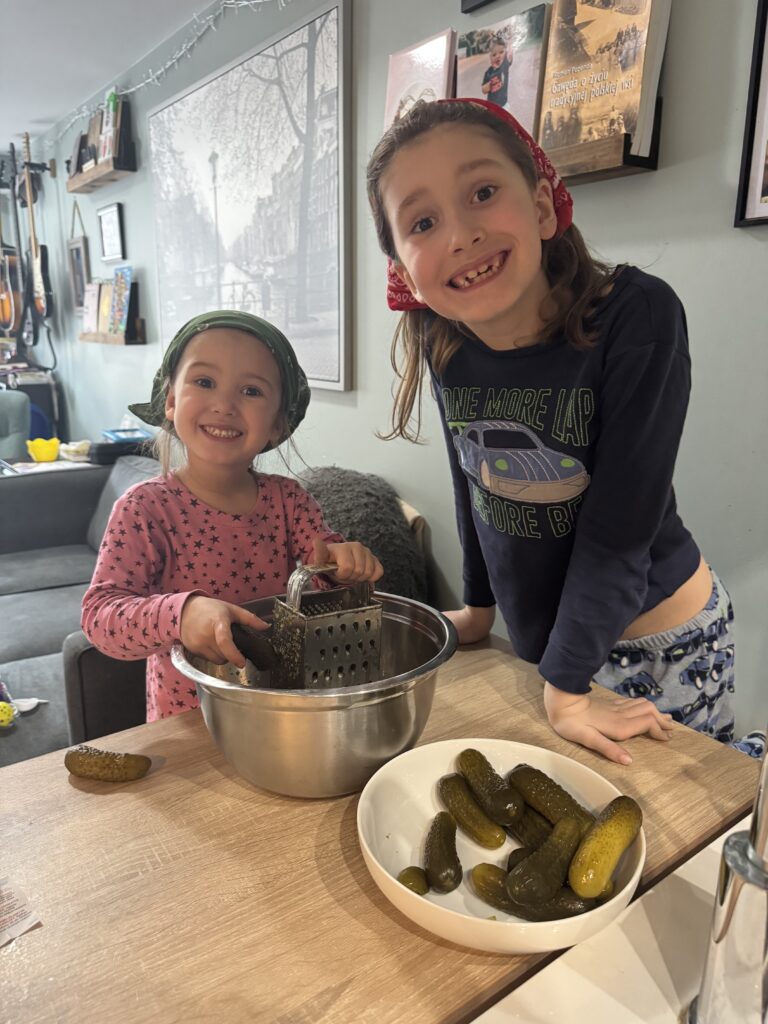 Children grating pickles to help make Zupa Ogórkowa, a traditional Polish dill pickle soup